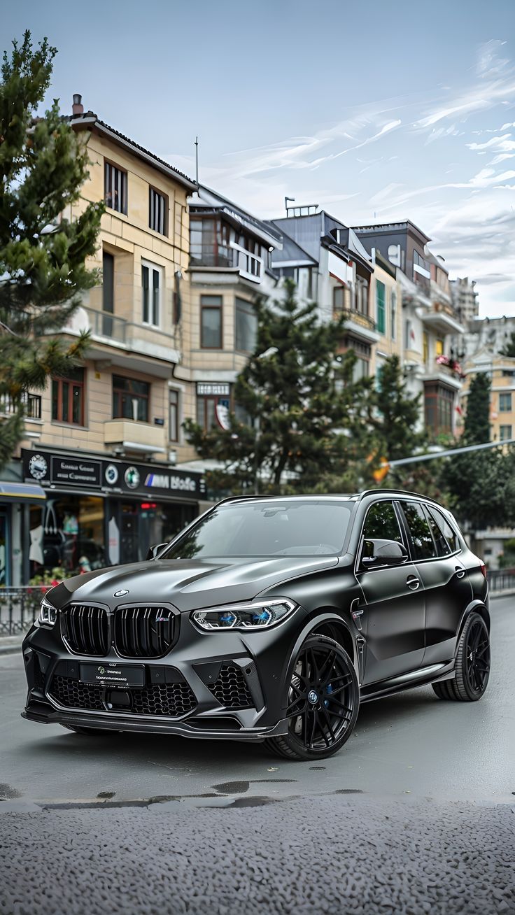 Matte-black performance SUV parked on a city street with European-style buildings behind.